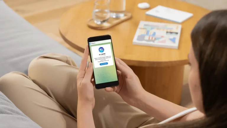 Žena držící mobilní telefon s Telegram skupinou AI v KAPSE na obrazovce.